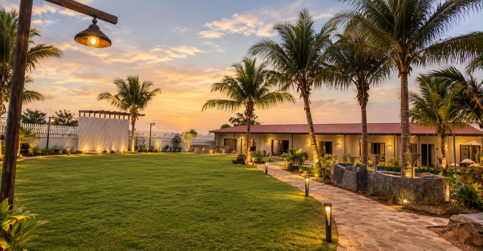Sprawling lawn with palms and lantern-lit stone pathway